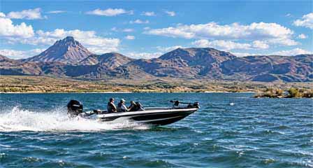 Two anglers fishing from a bass boat on Alamo Lake with desert mountains in western Arizona