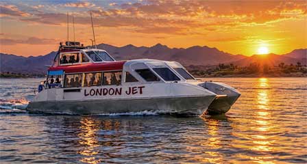 Tour boat cruising Lake Havasu near Lake Havasu City at sunset with desert mountains in the background