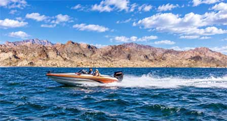 Fish and ski boat cruising across Lake Mohave with rugged desert mountains along the Arizona shoreline