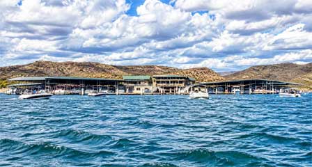 Pleasant Harbor Marina on Lake Pleasant with pleasure boats on blue water and surrounding desert mountains