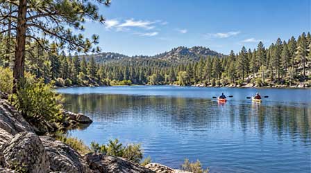 Kayakers paddling on Lynx Lake in the ponderosa pine forest near Prescott Arizona