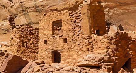 Close-up of ancient stone masonry rooms beneath a sandstone alcove at Palatki Heritage Site
