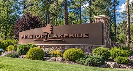 Welcome to Pinetop-Lakeside Arizona sign surrounded by pine trees and landscaping